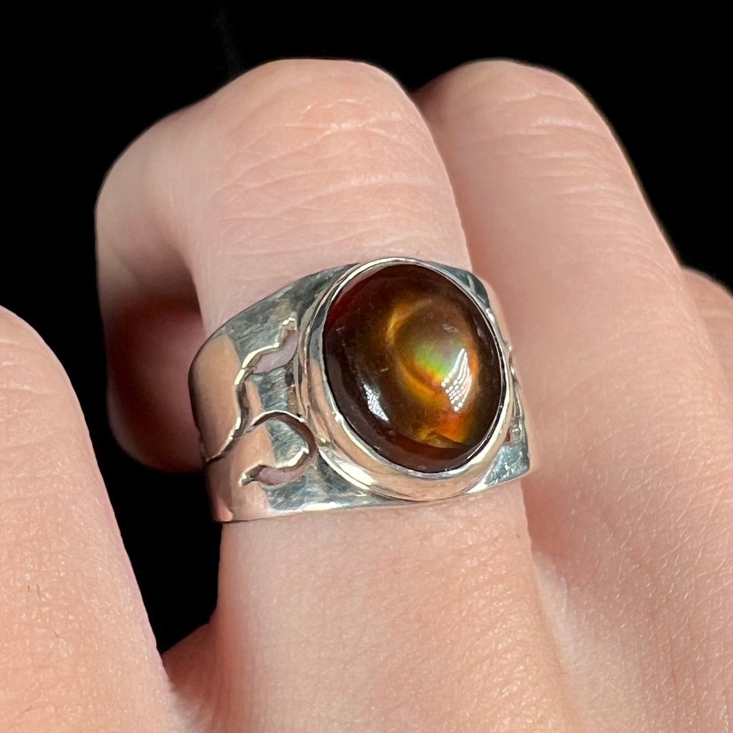 A unisex Mexican fire agate ring made from sterling silver, worn on a hand and shown at an angle.