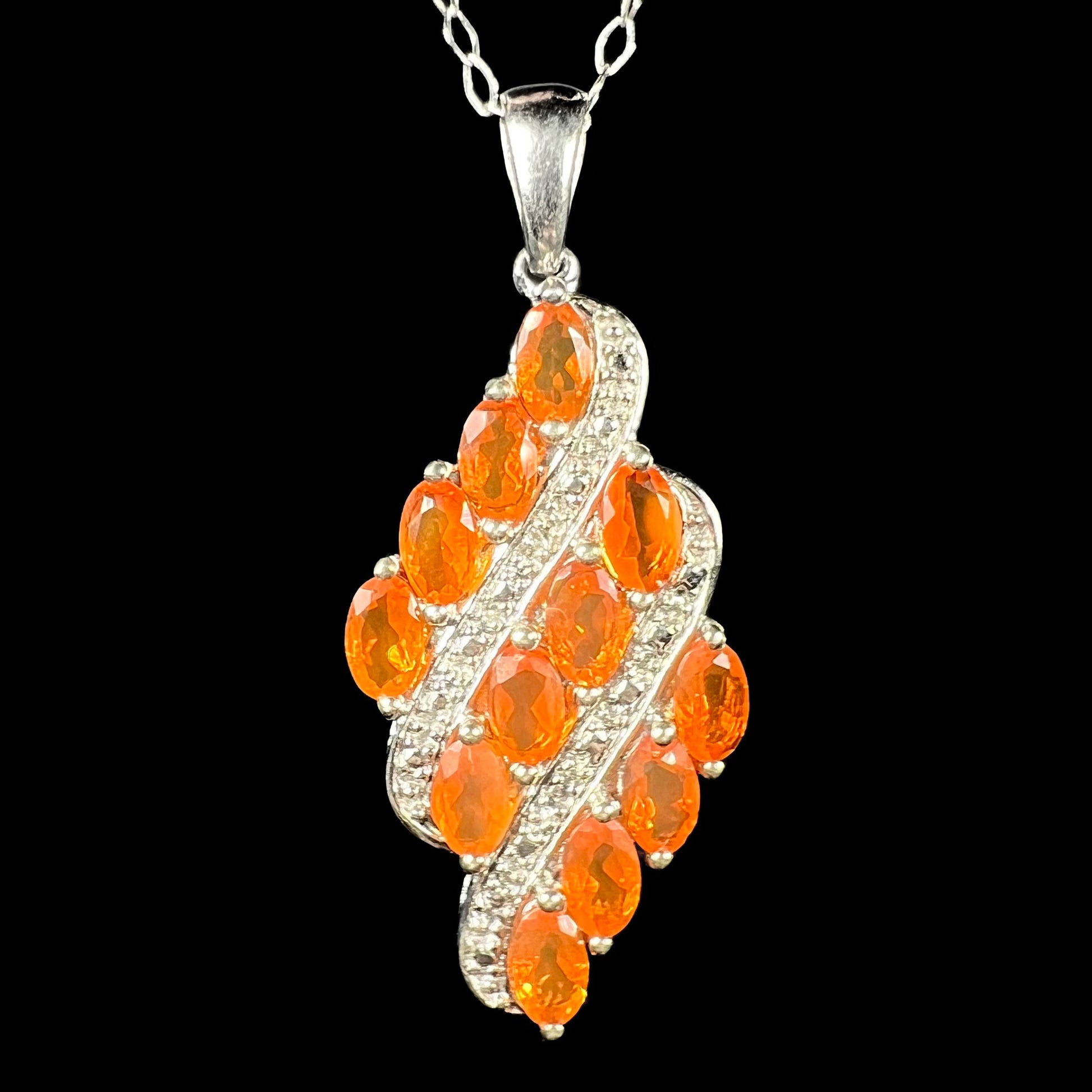 A silver Mexican fire opal necklace featuring a cluster of orange opals, shown from the front.
