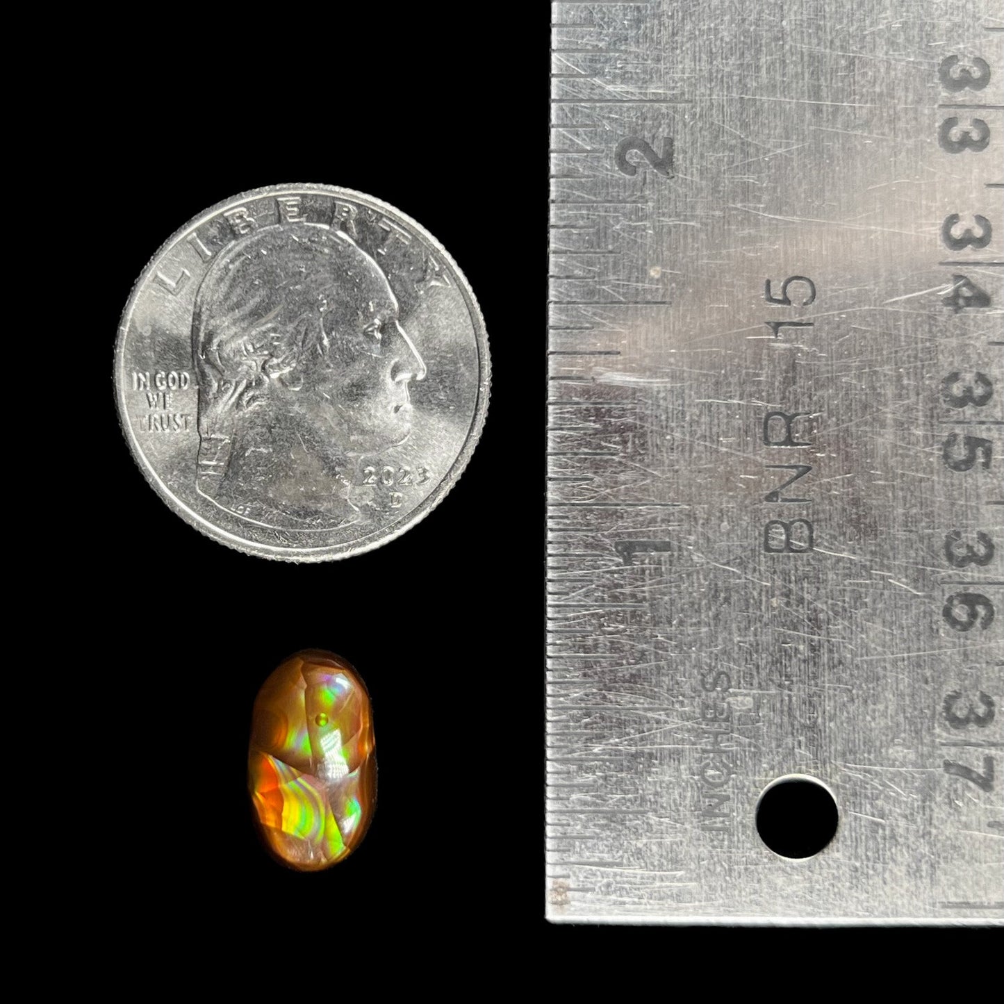 A loose, oval cabochon cut Mexican fire agate stone. The stone has multi-colored banding with blue overtones.