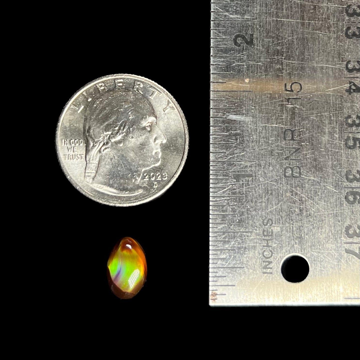 A loose, 3.38ct, pear shaped Mexican fire agate stone. The stone shines a vivid, bright green color with a purple streak.