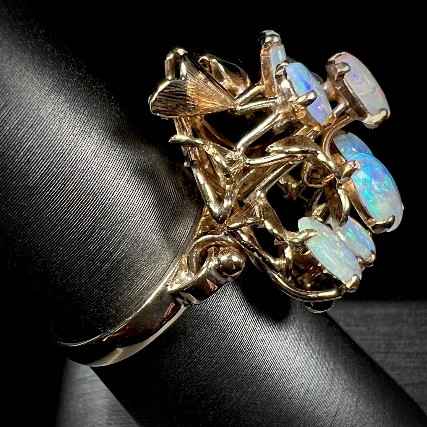 A ladies' vintage, modernist style opal cluster ring in yellow gold. The ring is tall with a high profile.