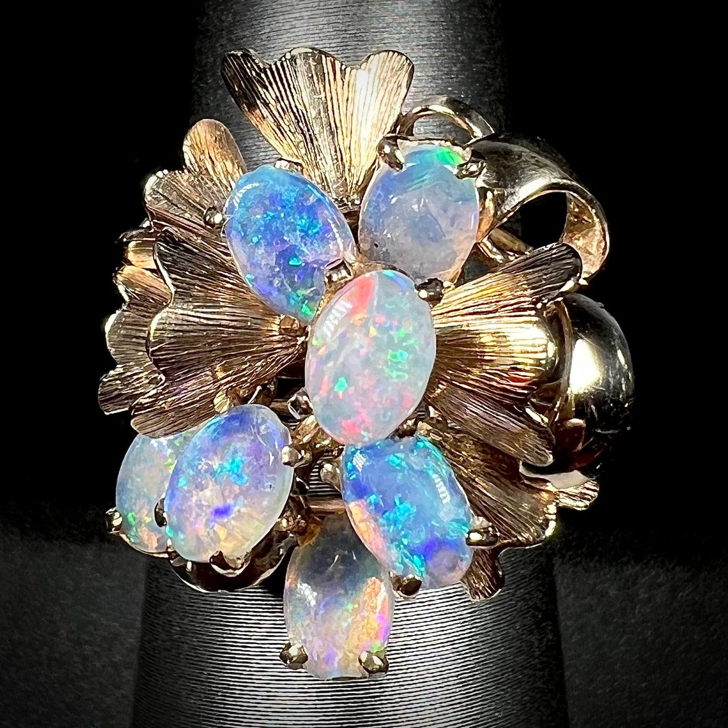 A ladies' vintage, modernist style opal cluster ring in yellow gold. The ring is tall with a high profile.