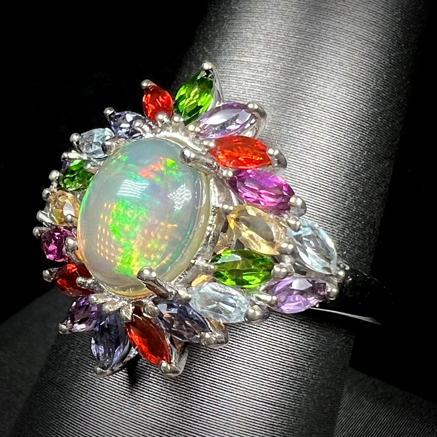 A multi-gemstone opal ring made from silver, shown at an angle.
