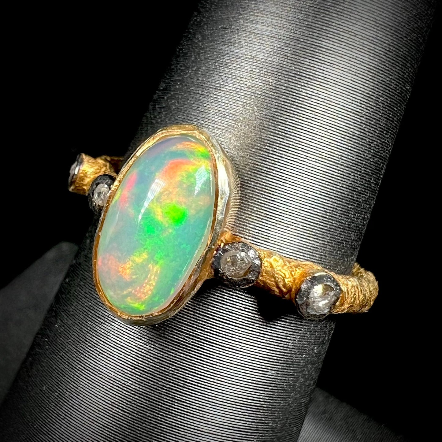A yellow gold plated sterling silver ring mounted with an Ethiopian fire opal and rose cut diamond accents.