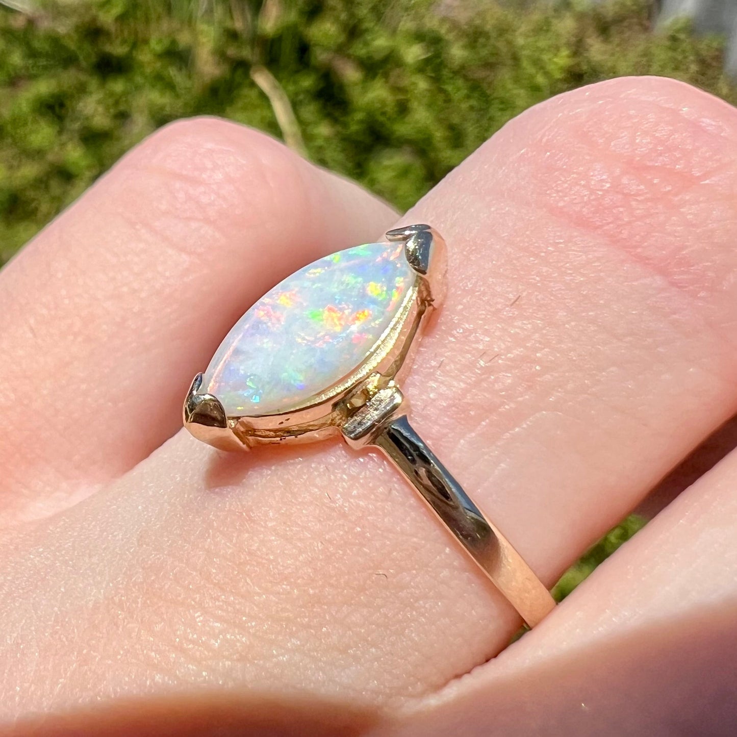 A marquise cut natural opal solitaire ring in yellow gold.