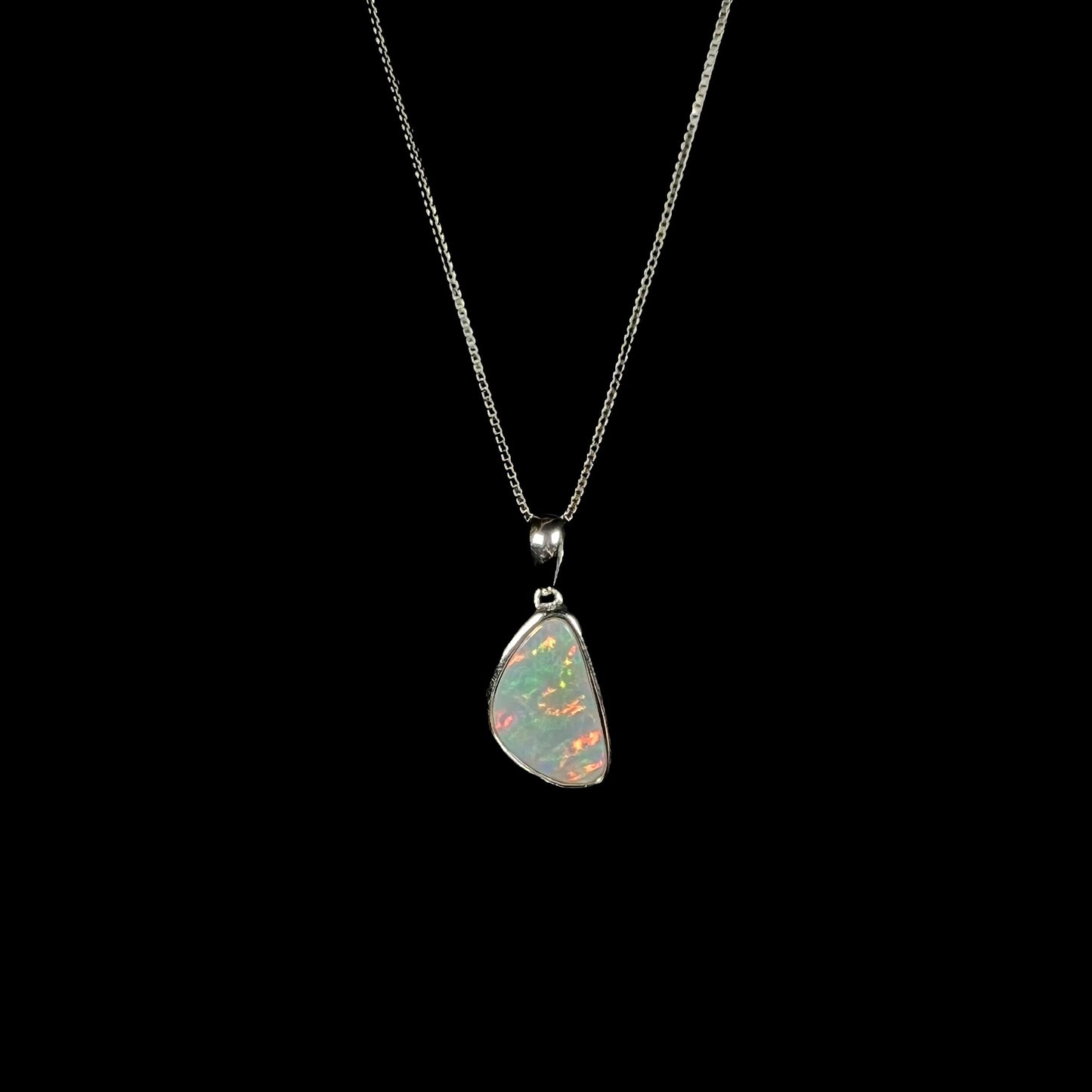 A sterling silver pendant bezel set with a white Australian crystal opal on a box chain.