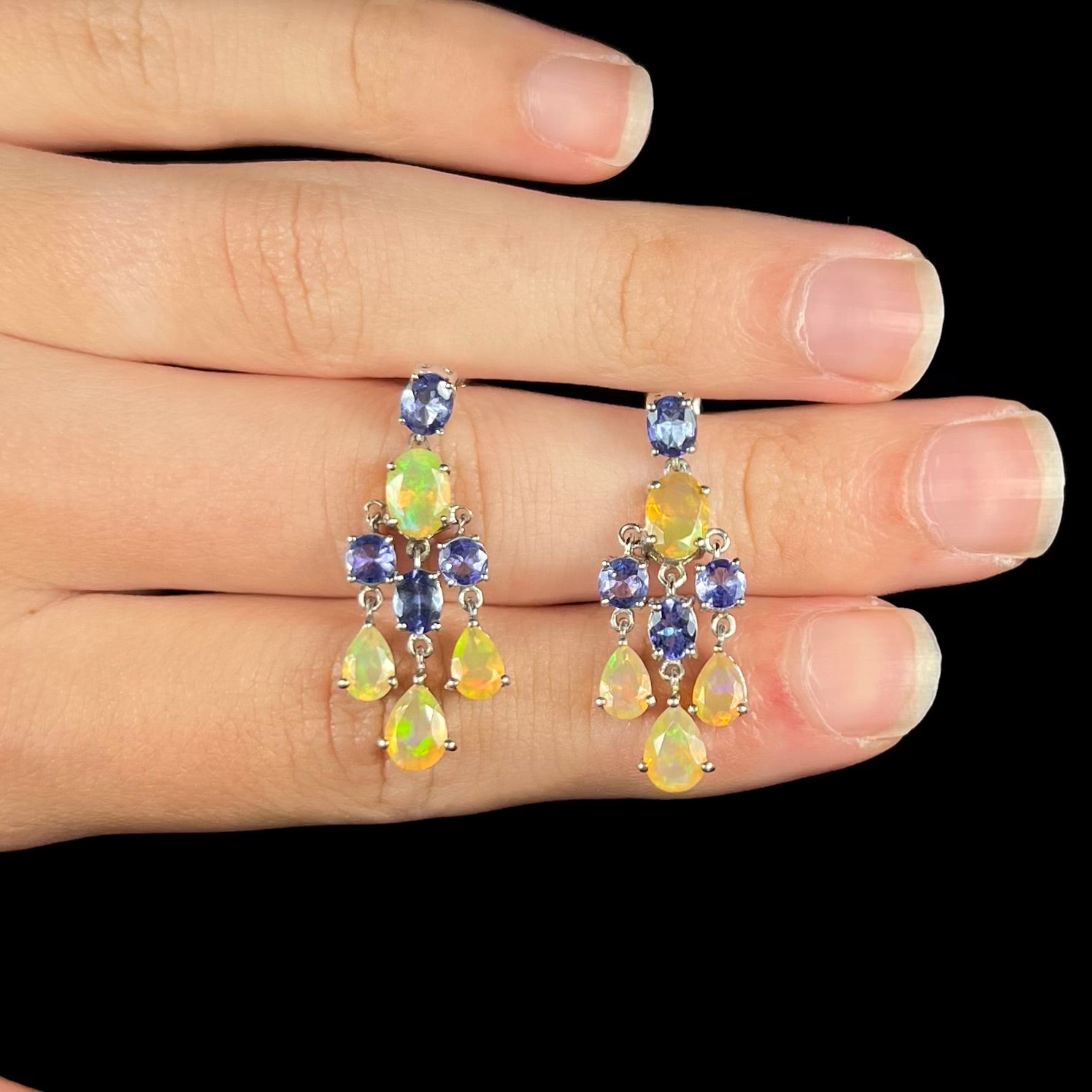 A pair of dangling sterling silver Ethiopian opal and tanzanite chandelier earrings.