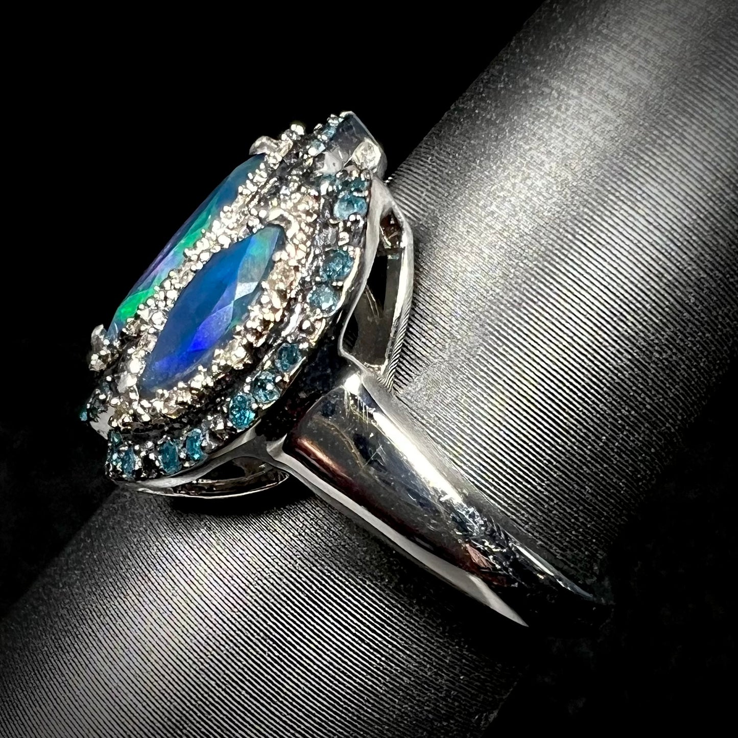 Side view of a sterling silver opal and blue diamond ring, focusing on the ring's shank.