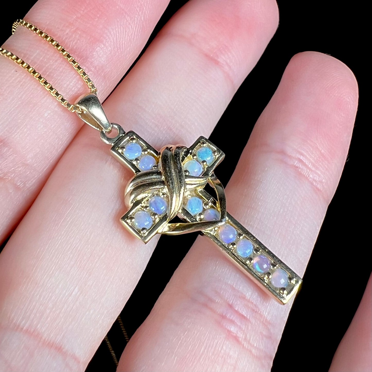 Angled macro view of opal cross necklace with subtle color play.