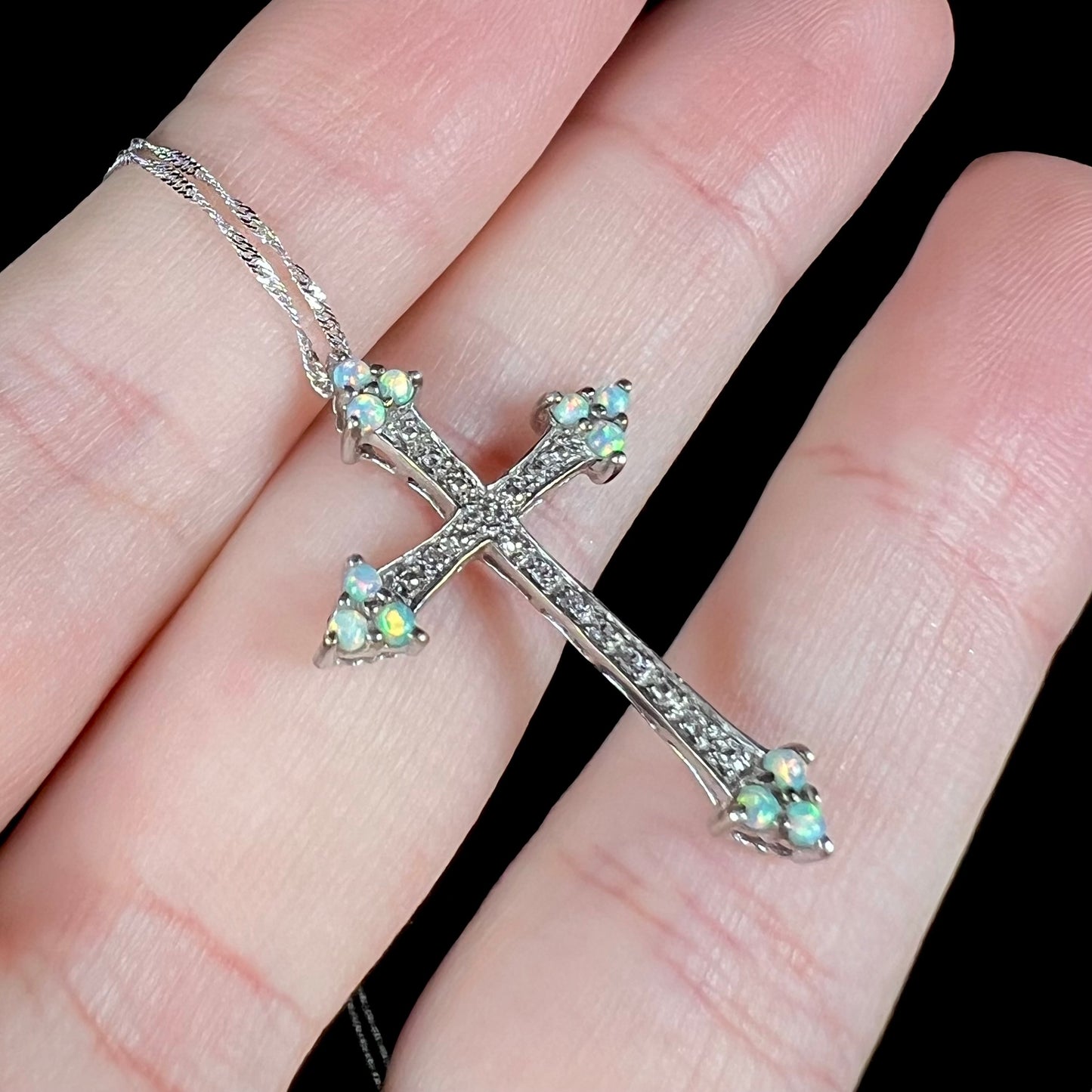 A sterling silver lab-created opal cross necklace with CZ accents.