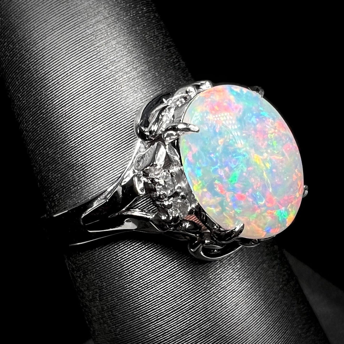 A platinum and diamond ring prong-set with an Australian opal. The opal has pink color play.