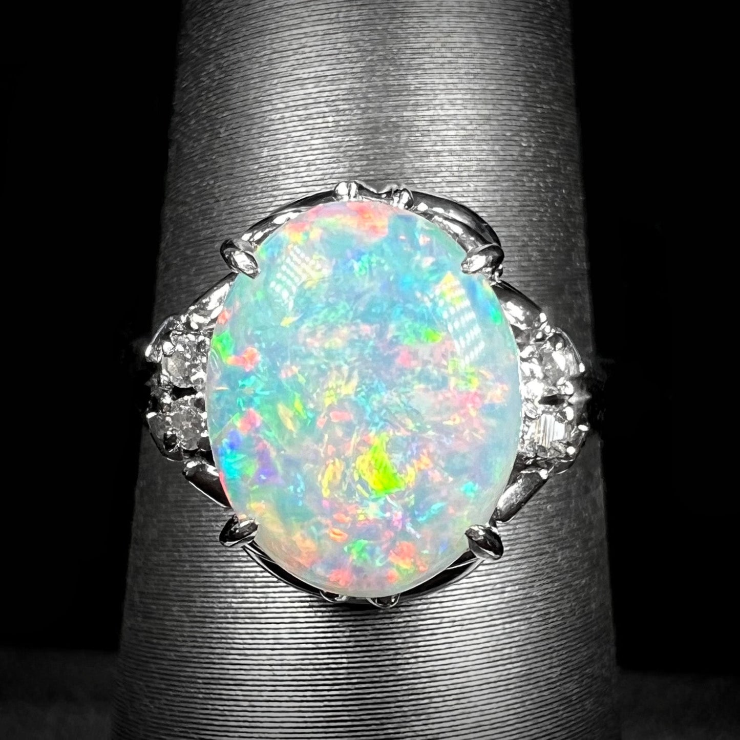 A platinum and diamond ring prong-set with an Australian opal. The opal has pink color play.
