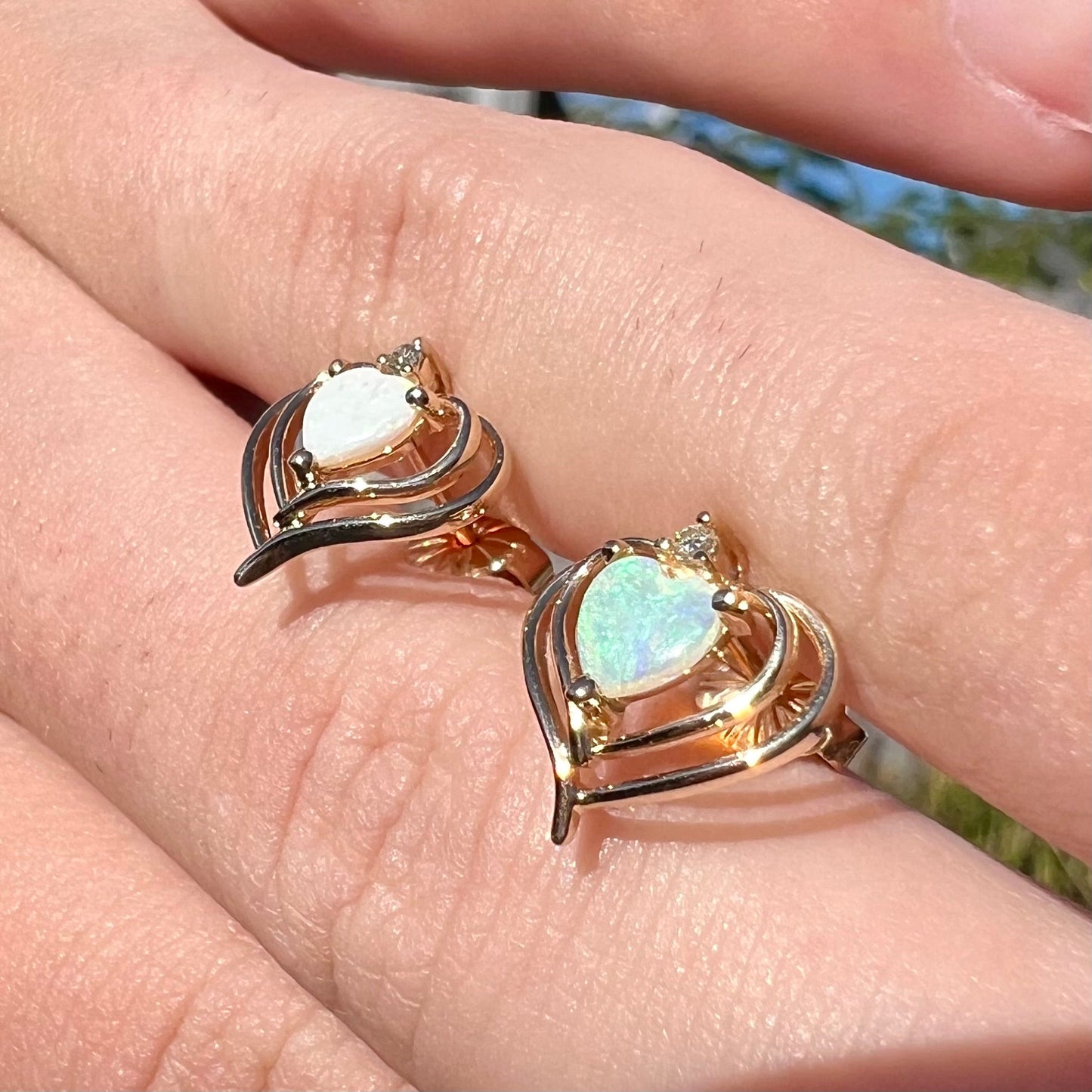 A pair of yellow gold heart shaped stud earrings set with heart shaped natural opals.