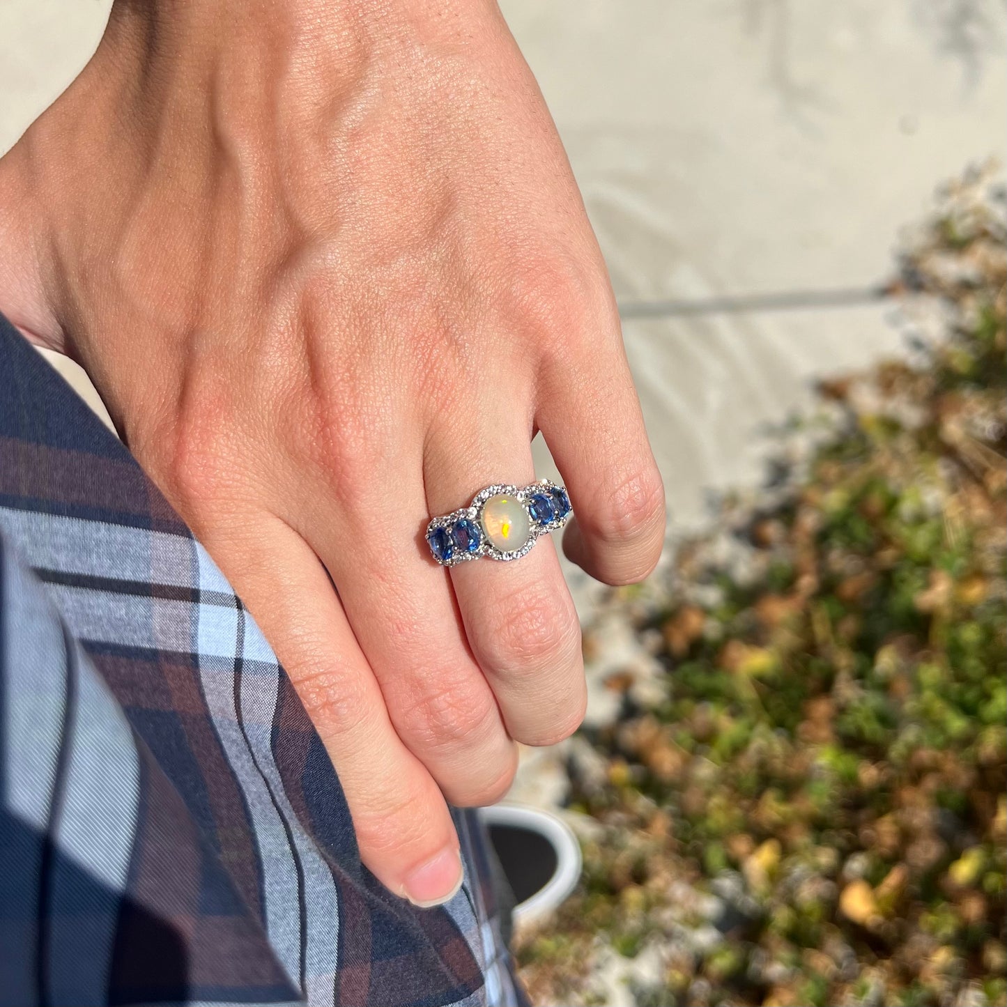 Sterling silver Ethiopian opal and kyanite ring worn on a hand, resting on the model's hip.