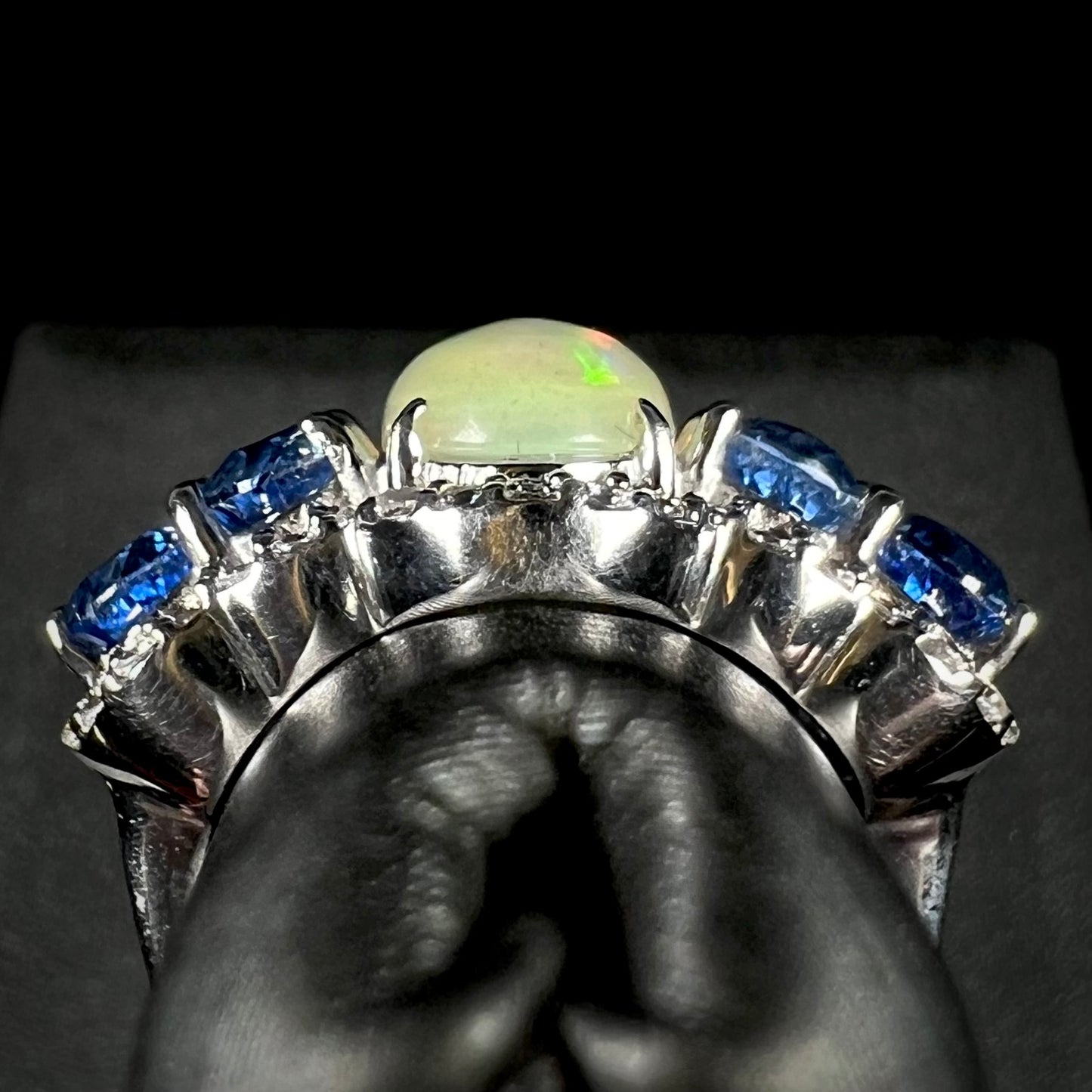 An Ethiopian opal and kyanite ring showing the ring's side gallery view.