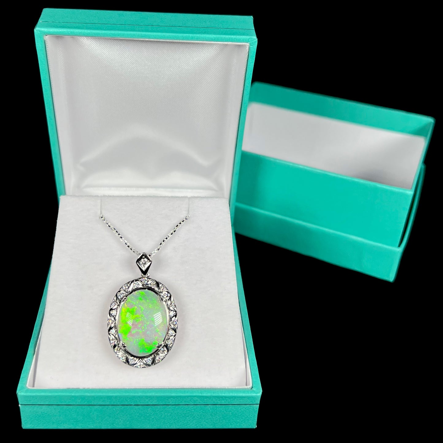 Platinum opal necklace displayed in a blue pendant box against a black background.