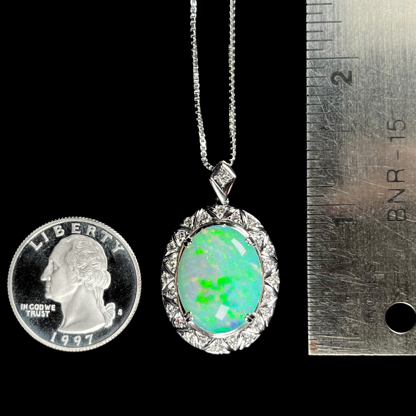 Coober Pedy opal pendant with quarter and ruler for size reference, measuring approximately 1.33 inches.