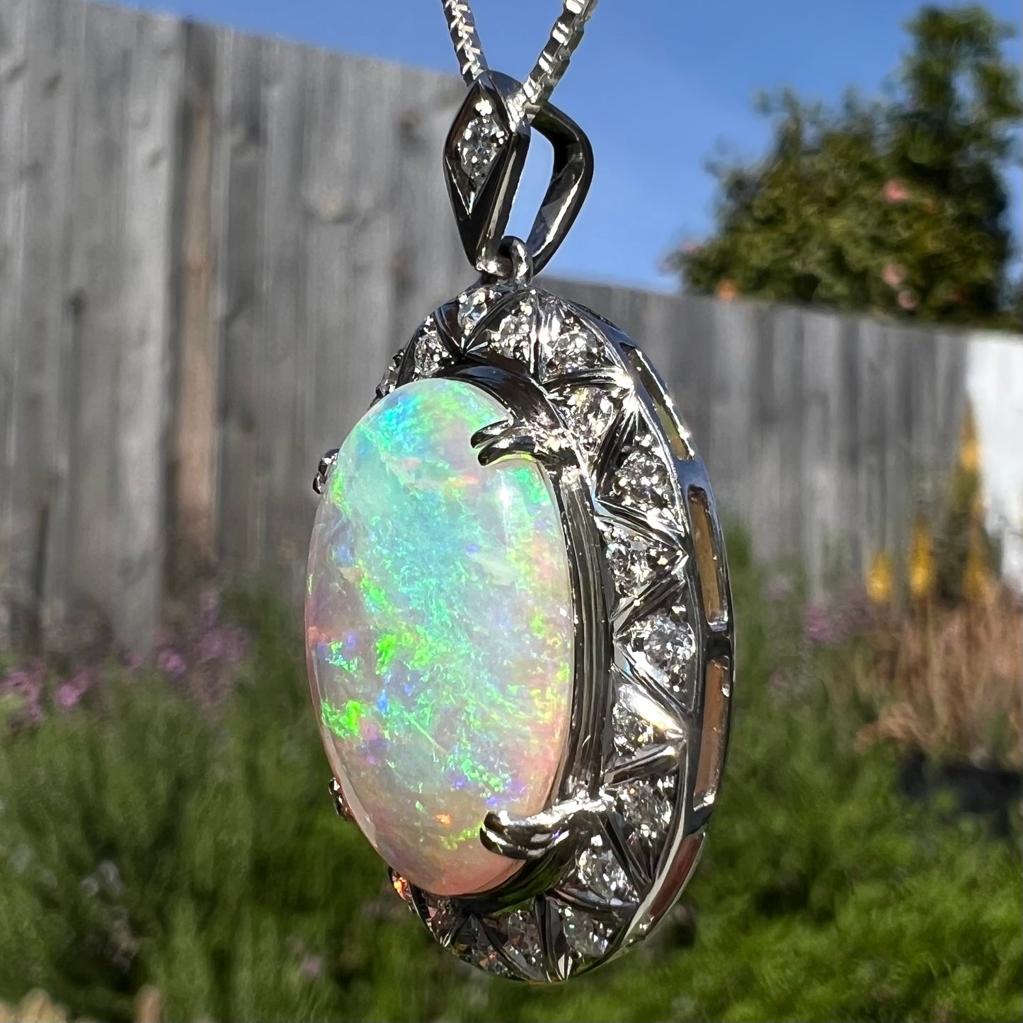 Angled photo of pendant in sunlight showing blue flashes on opposite side.