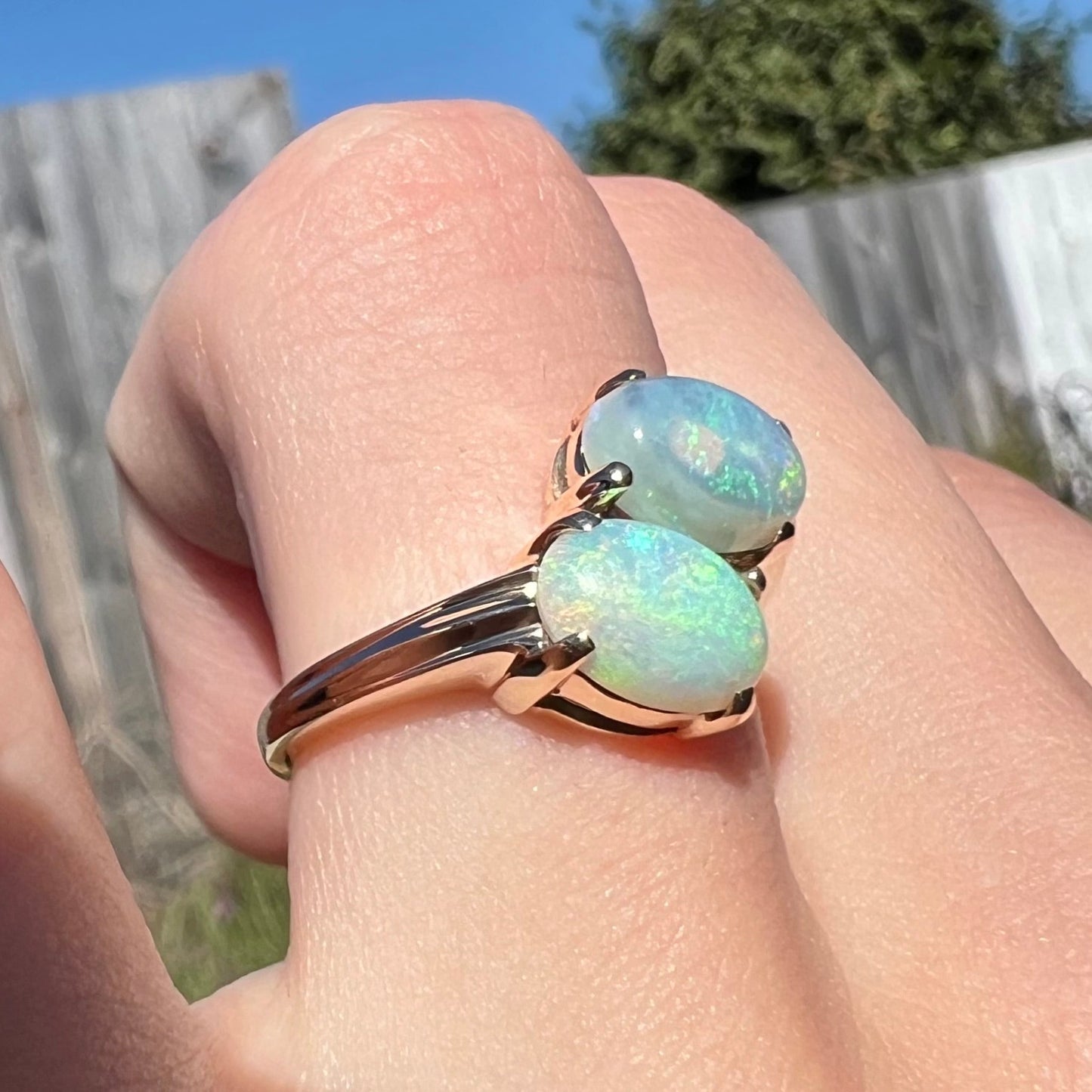 A yellow gold ring mounted with two oval cut semi-crystal opals from Coober Pedy, Australia.