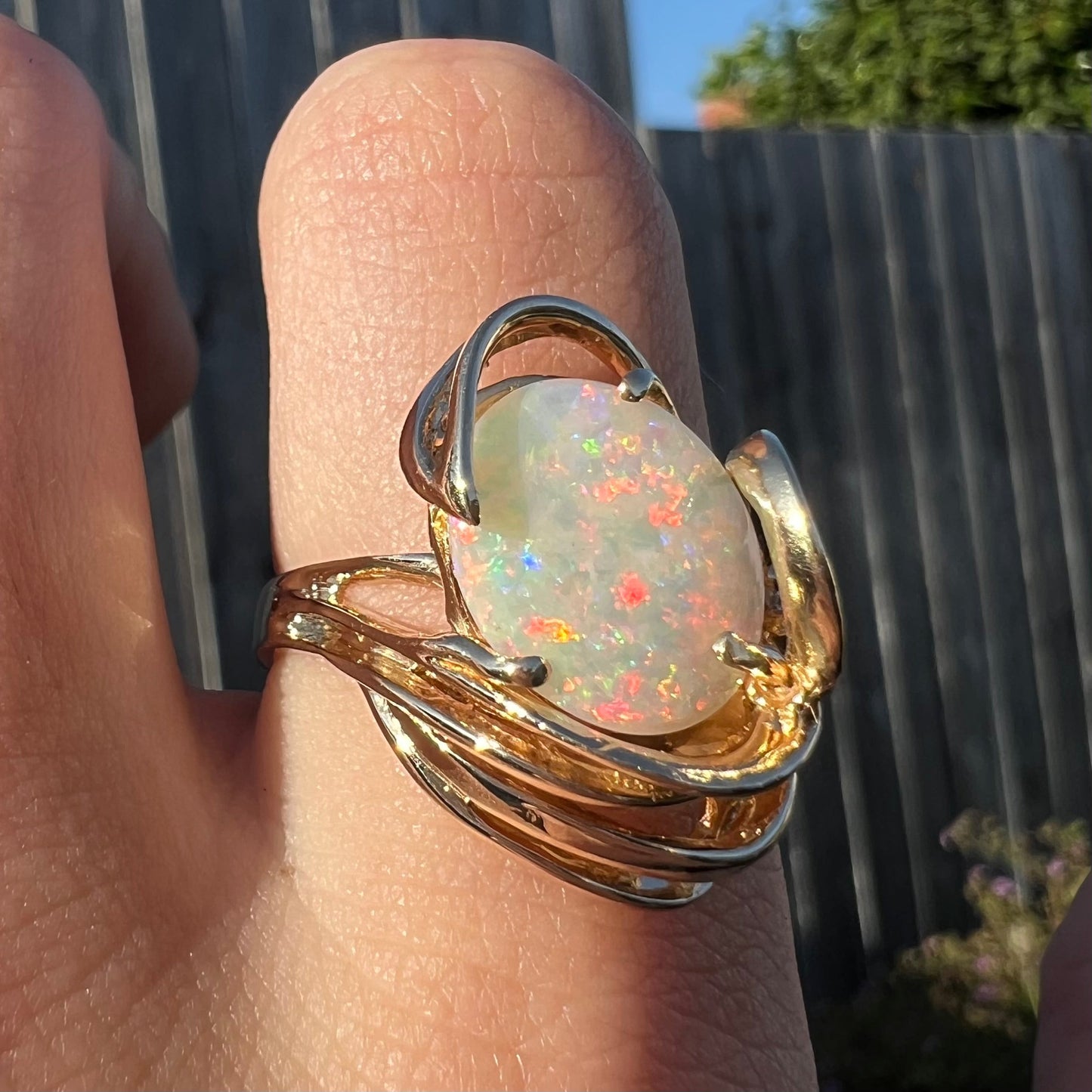 A ladies' yellow gold cocktail ring set with bright white opal stone.