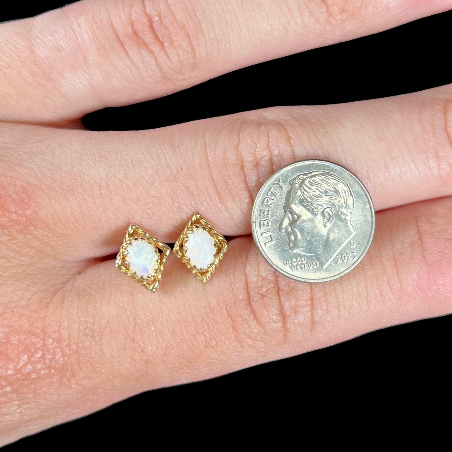 A pair of opal stud earrings. The opals are set in yellow gold diamond shaped mountings.