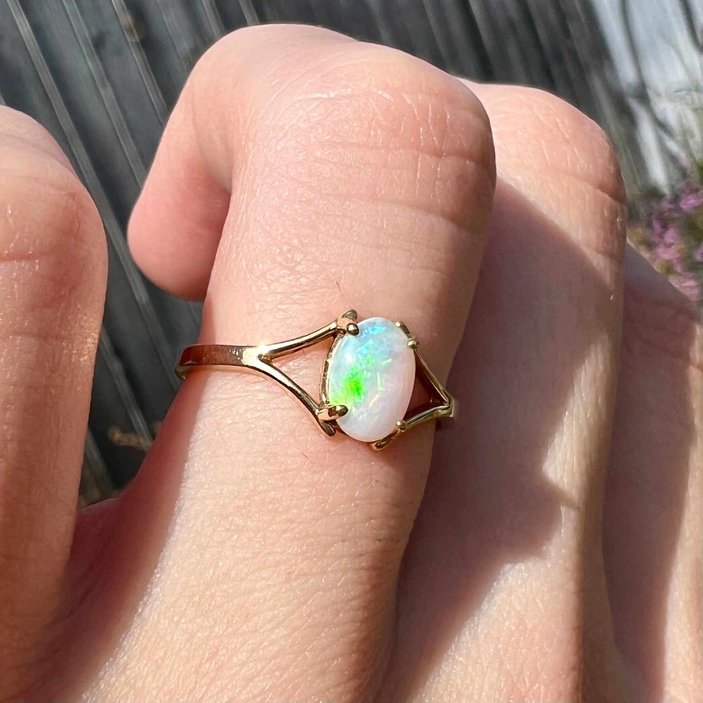 A ladies' simple opal solitaire ring. The ring is yellow gold with a split shank.