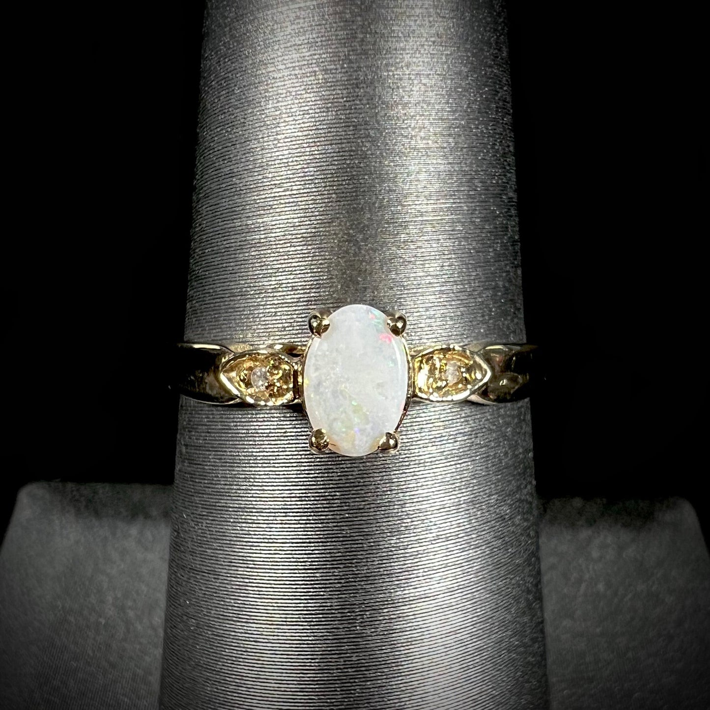 A dainty ladies' yellow gold opal and diamond ring. The opal has subtle play of color.