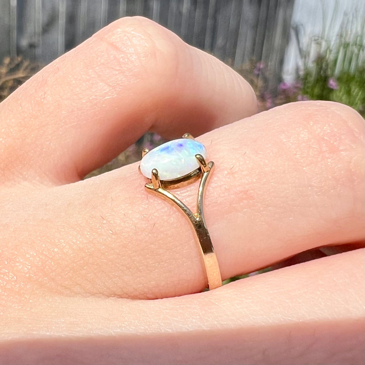 A ladies' simple opal solitaire ring. The ring is yellow gold with a split shank.