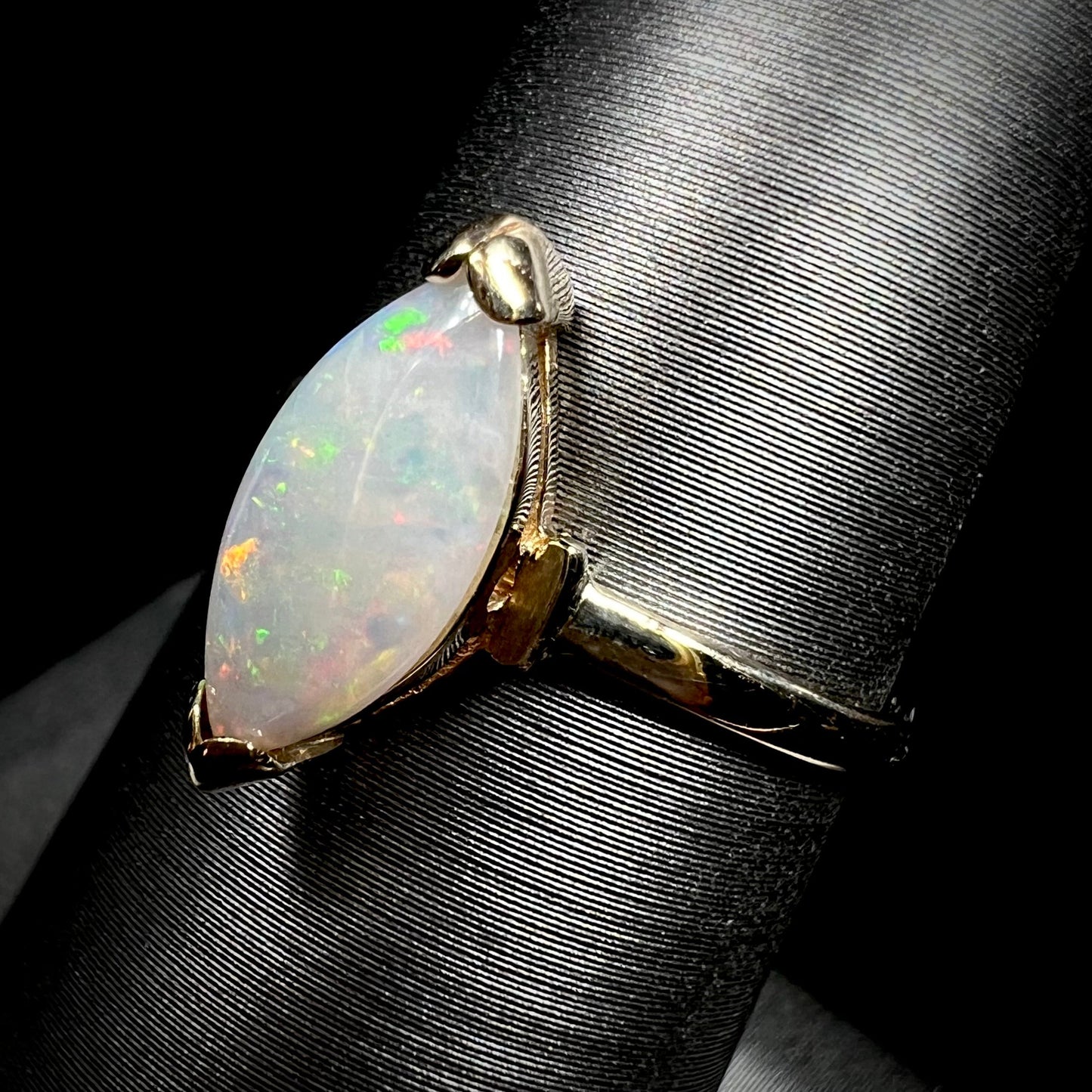 A marquise cut natural opal solitaire ring in yellow gold.