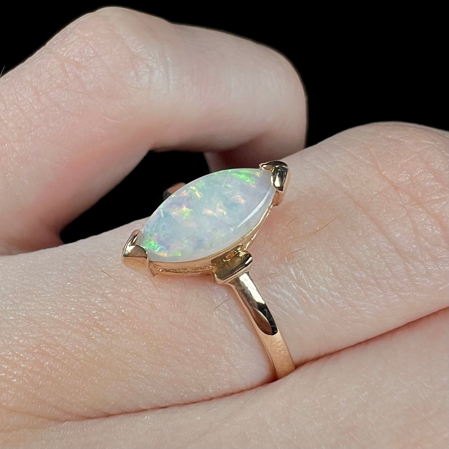 A marquise cut natural opal solitaire ring in yellow gold.