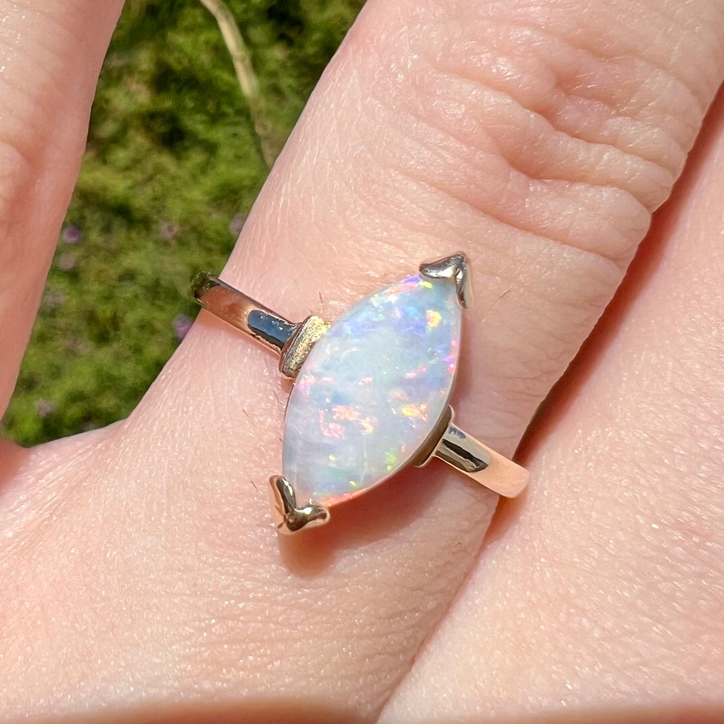 A marquise cut natural opal solitaire ring in yellow gold.