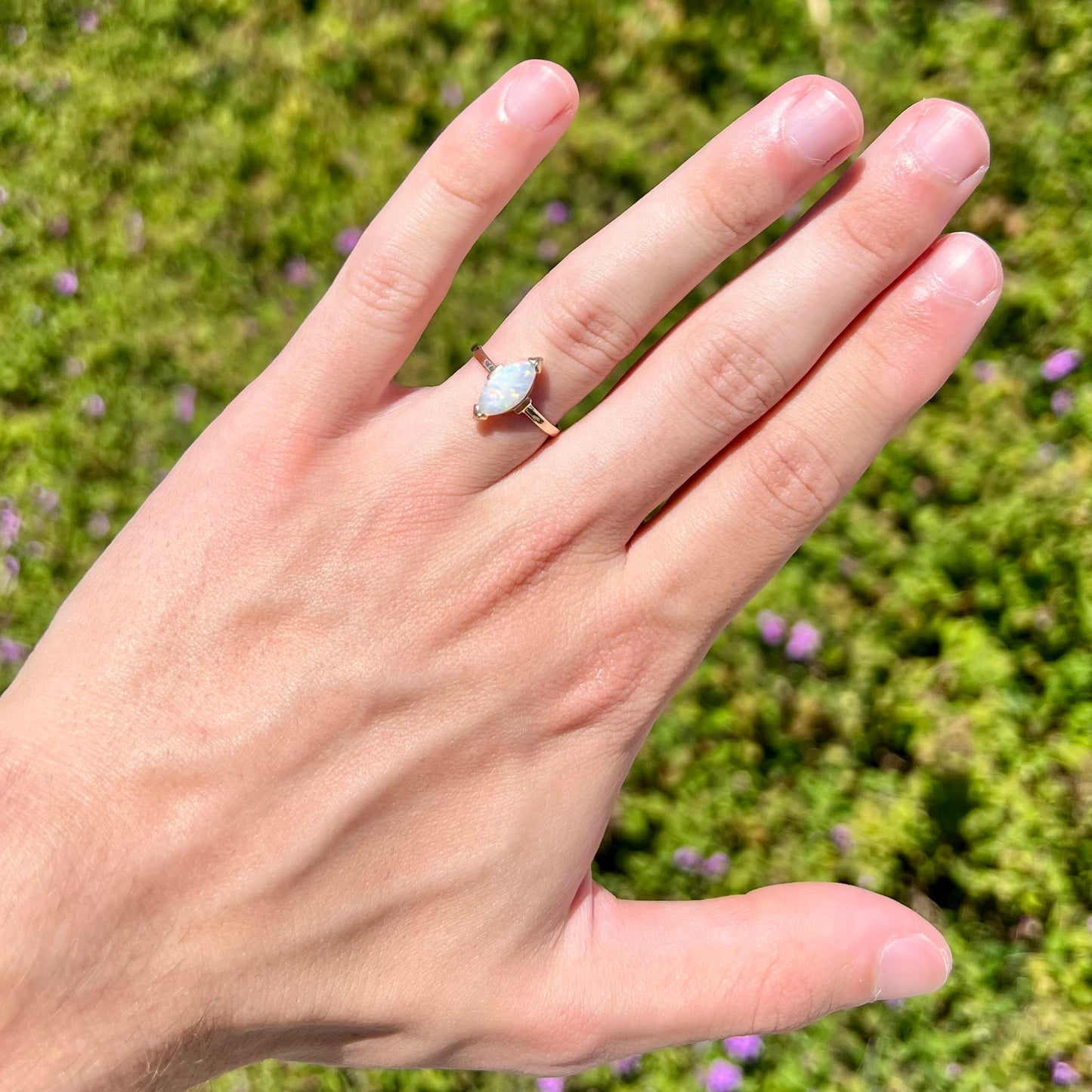 A marquise cut natural opal solitaire ring in yellow gold.