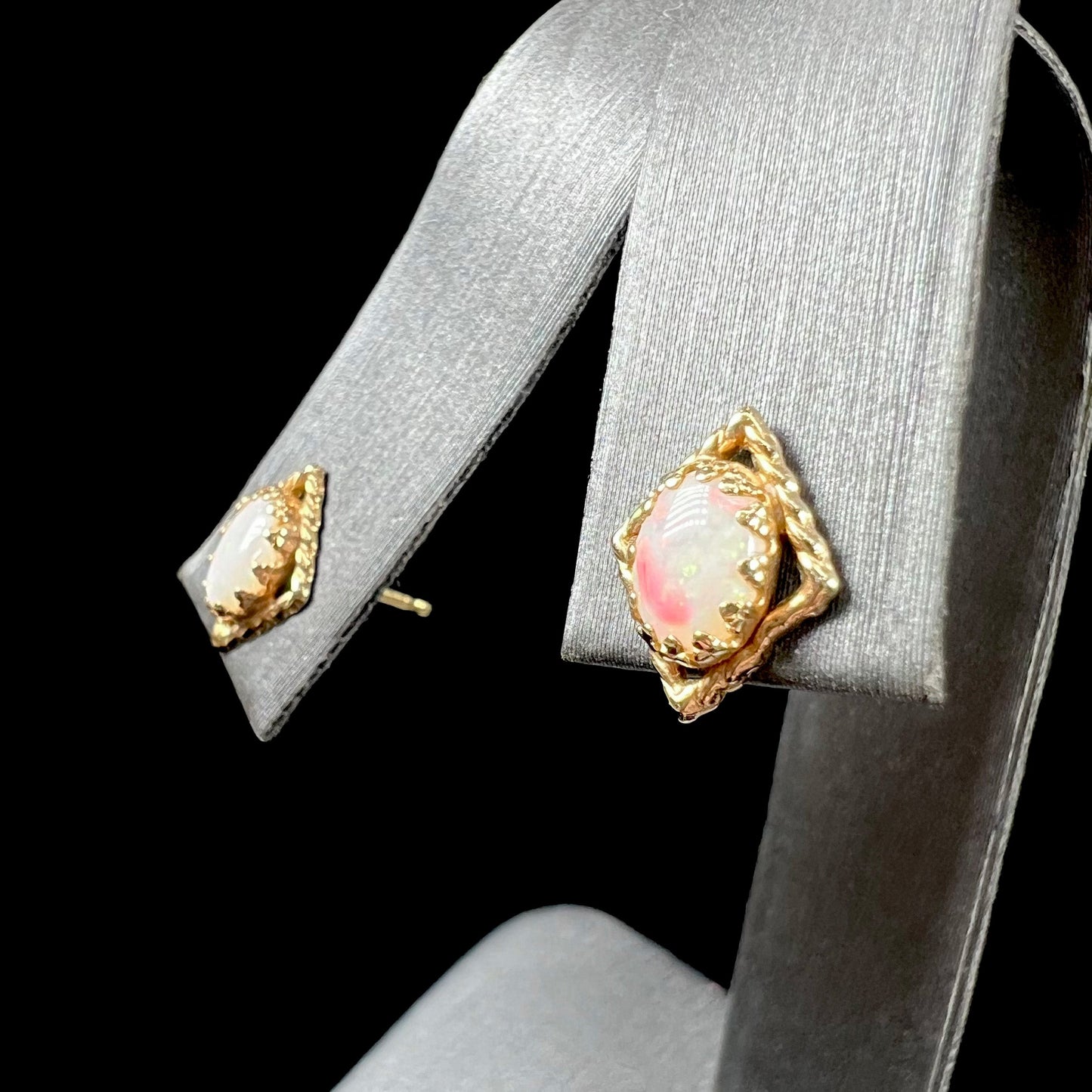 A pair of opal stud earrings. The opals are set in yellow gold diamond shaped mountings.