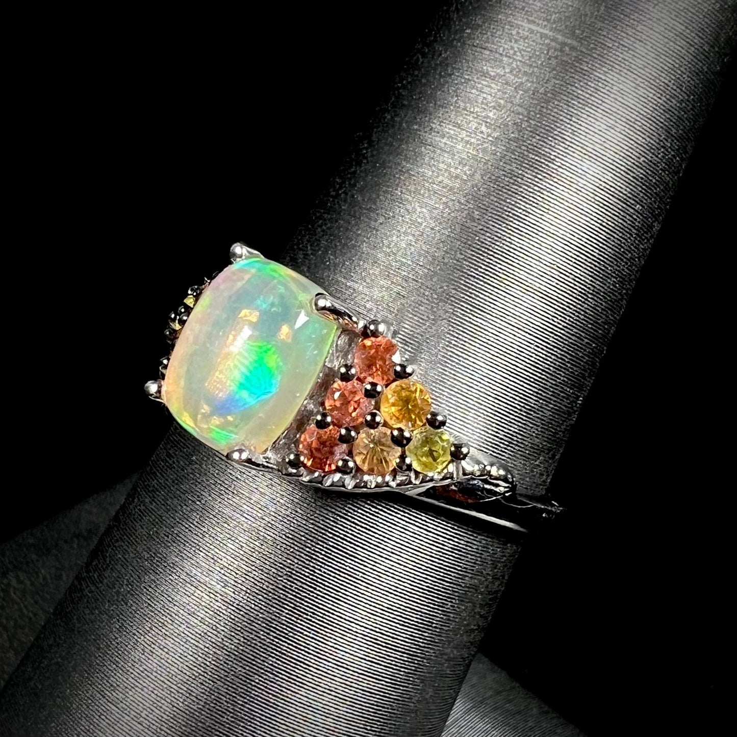 A ladies' silver ring set with a cushion cabochon cut Ethiopian fire opal stone and citrine accents.