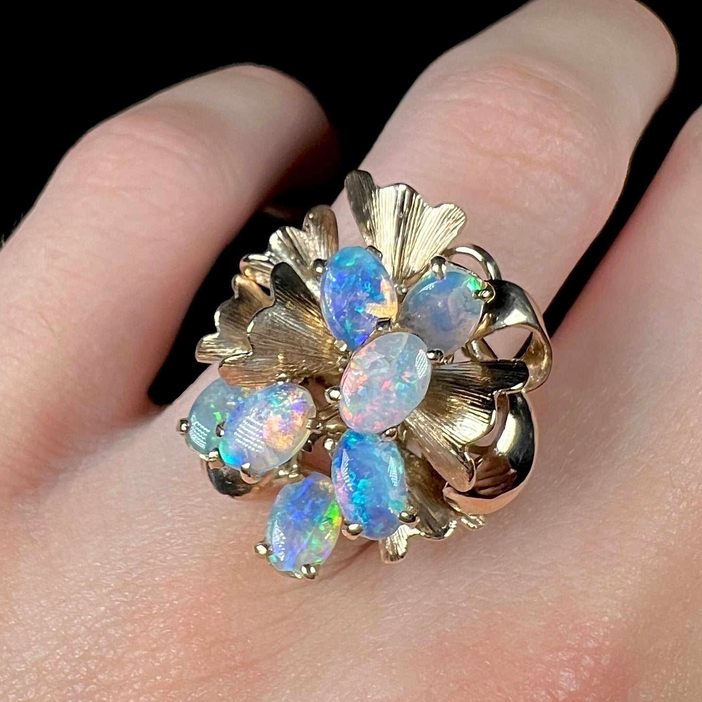 A ladies' vintage, modernist style opal cluster ring in yellow gold. The ring is tall with a high profile.