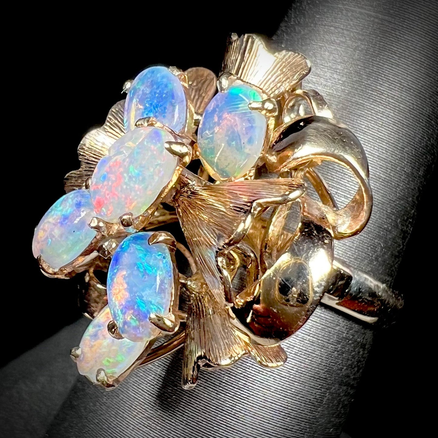 A ladies' vintage, modernist style opal cluster ring in yellow gold. The ring is tall with a high profile.