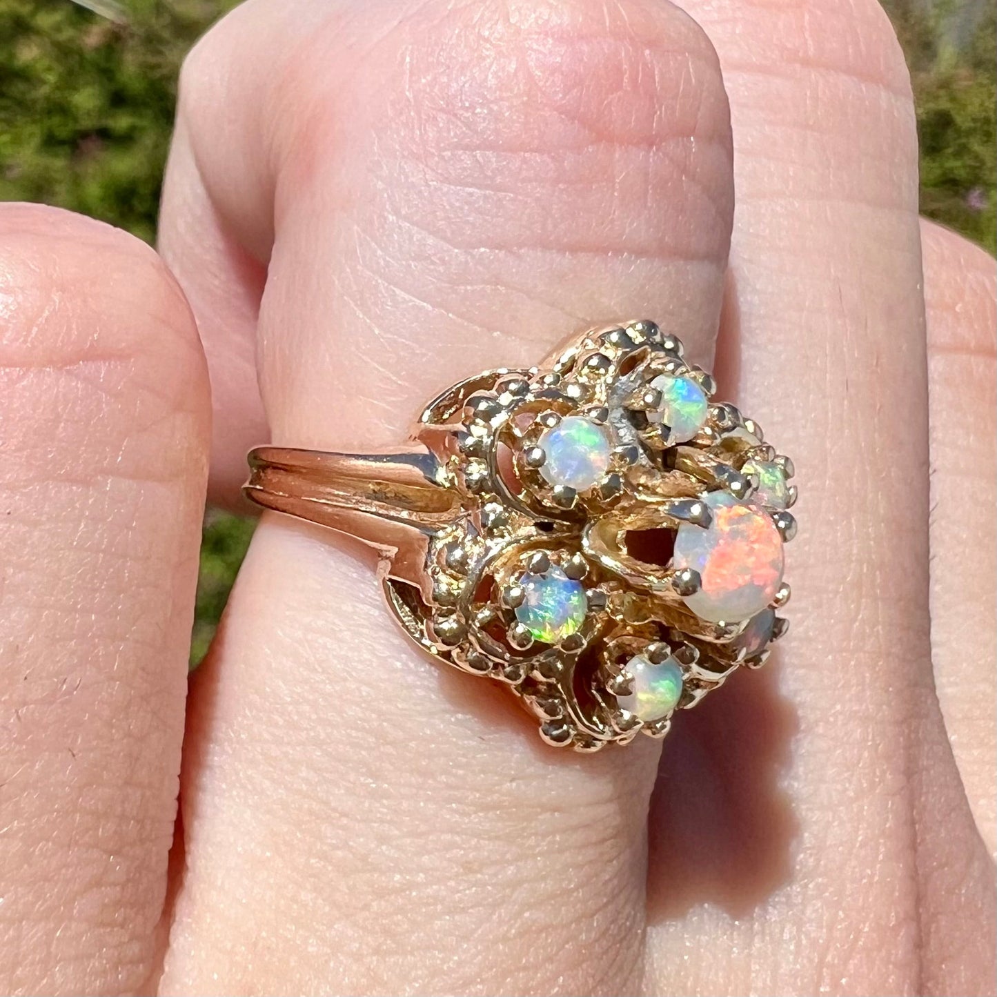 A vintage, mid-century style round opal cluster ring in yellow gold.