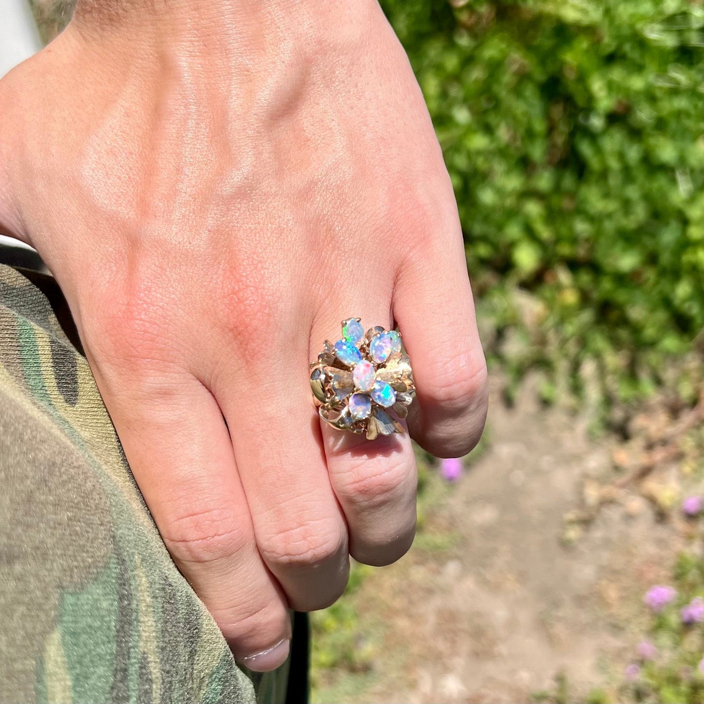 A ladies' vintage, modernist style opal cluster ring in yellow gold. The ring is tall with a high profile.