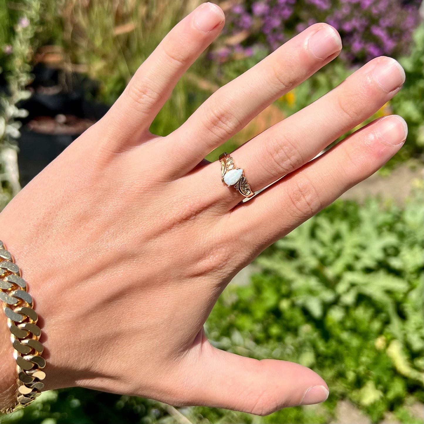 A ladies' two-tone yellow and rose Black Hills gold opal and diamond ring. The opal is a pear shaped cabochon.
