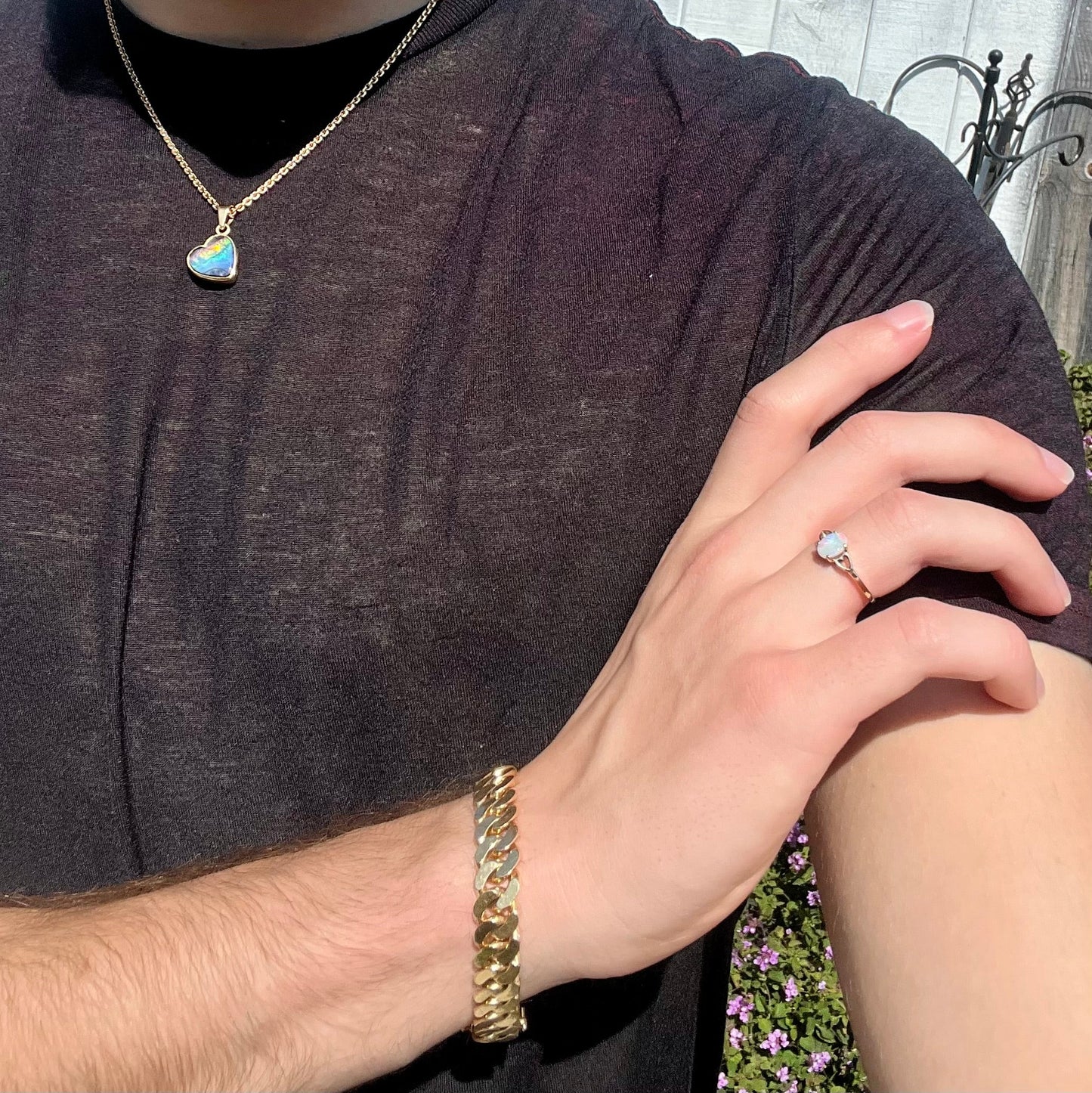A dainty yellow gold ring mounted with a vivdly bright red Australian opal. The ring has two heart shaped designs.