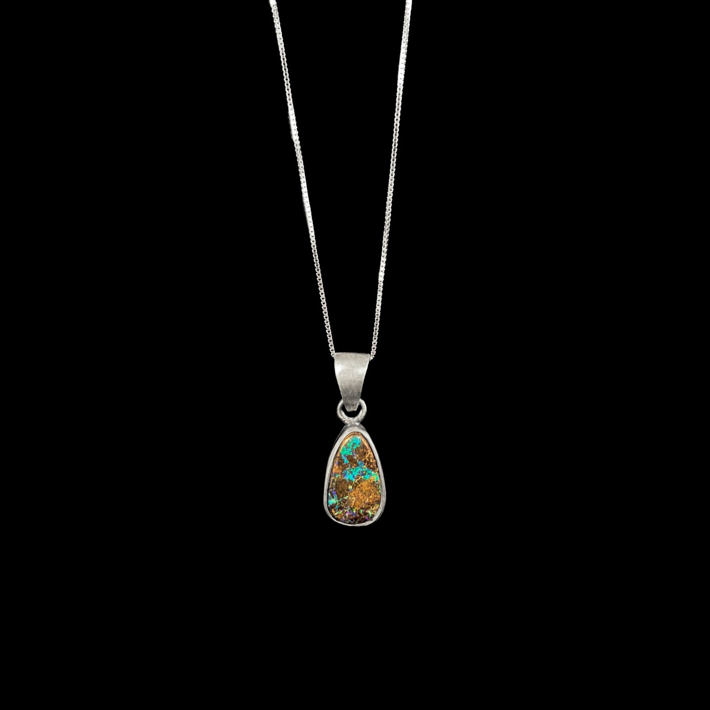 A handmade, satin finish sterling silver pendant set with a drop shaped boulder opal stone.