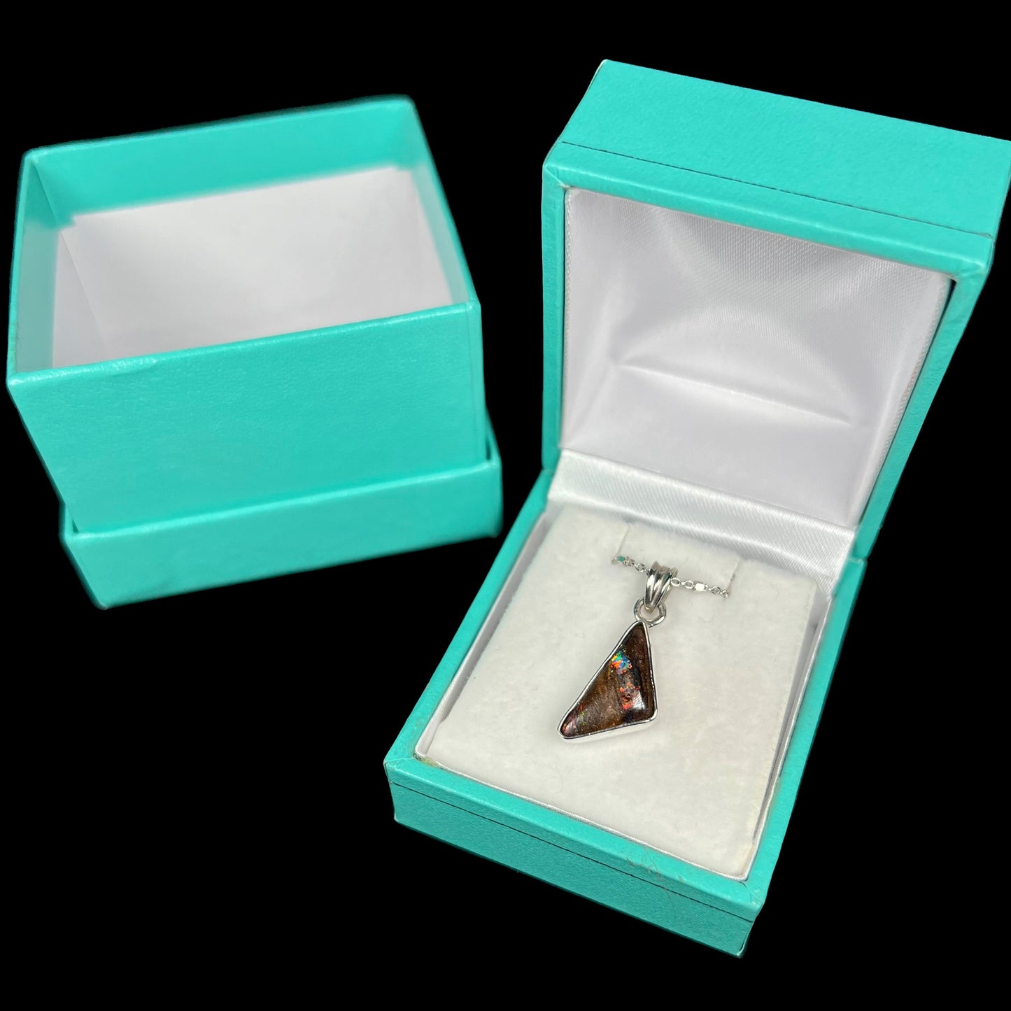 A triangle shaped opal necklace in sterling silver.  The opal shines with every color of the rainbow.