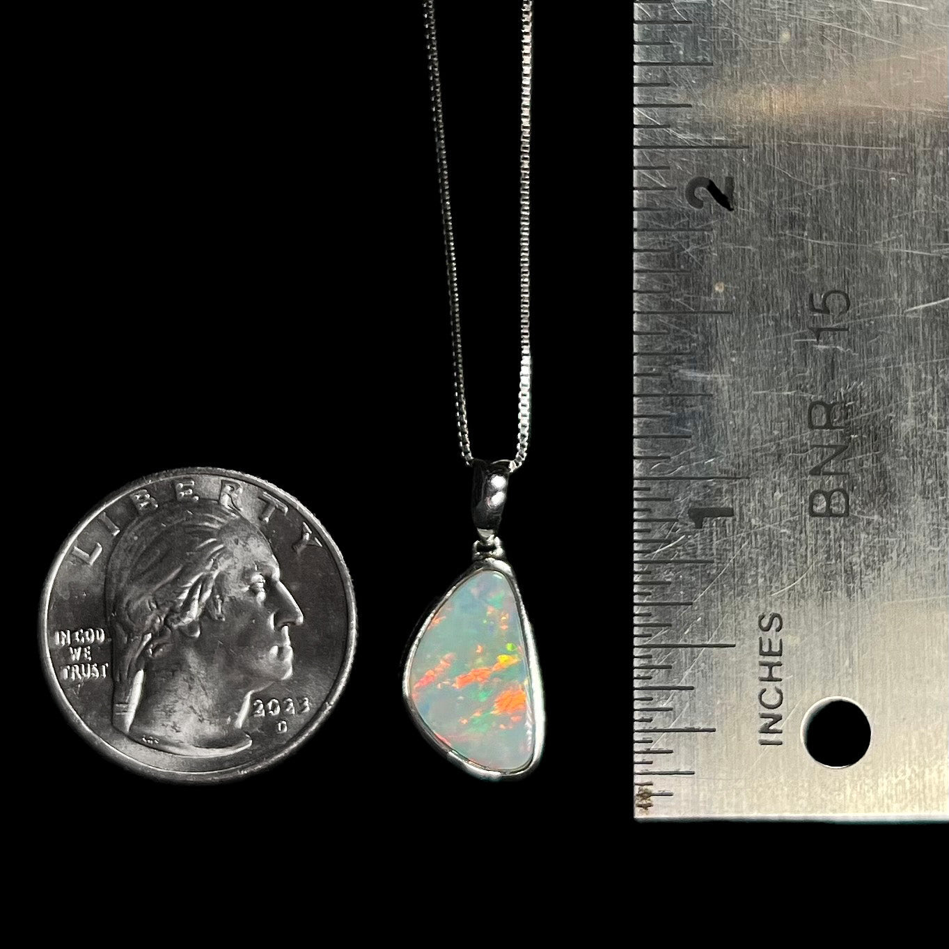 A sterling silver pendant bezel set with a white Australian crystal opal on a box chain.