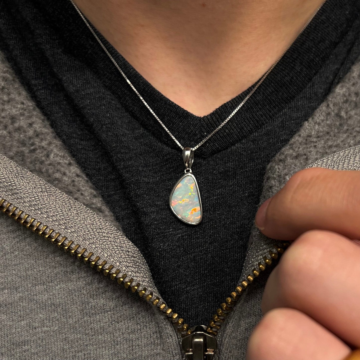 A sterling silver pendant bezel set with a white Australian crystal opal on a box chain.