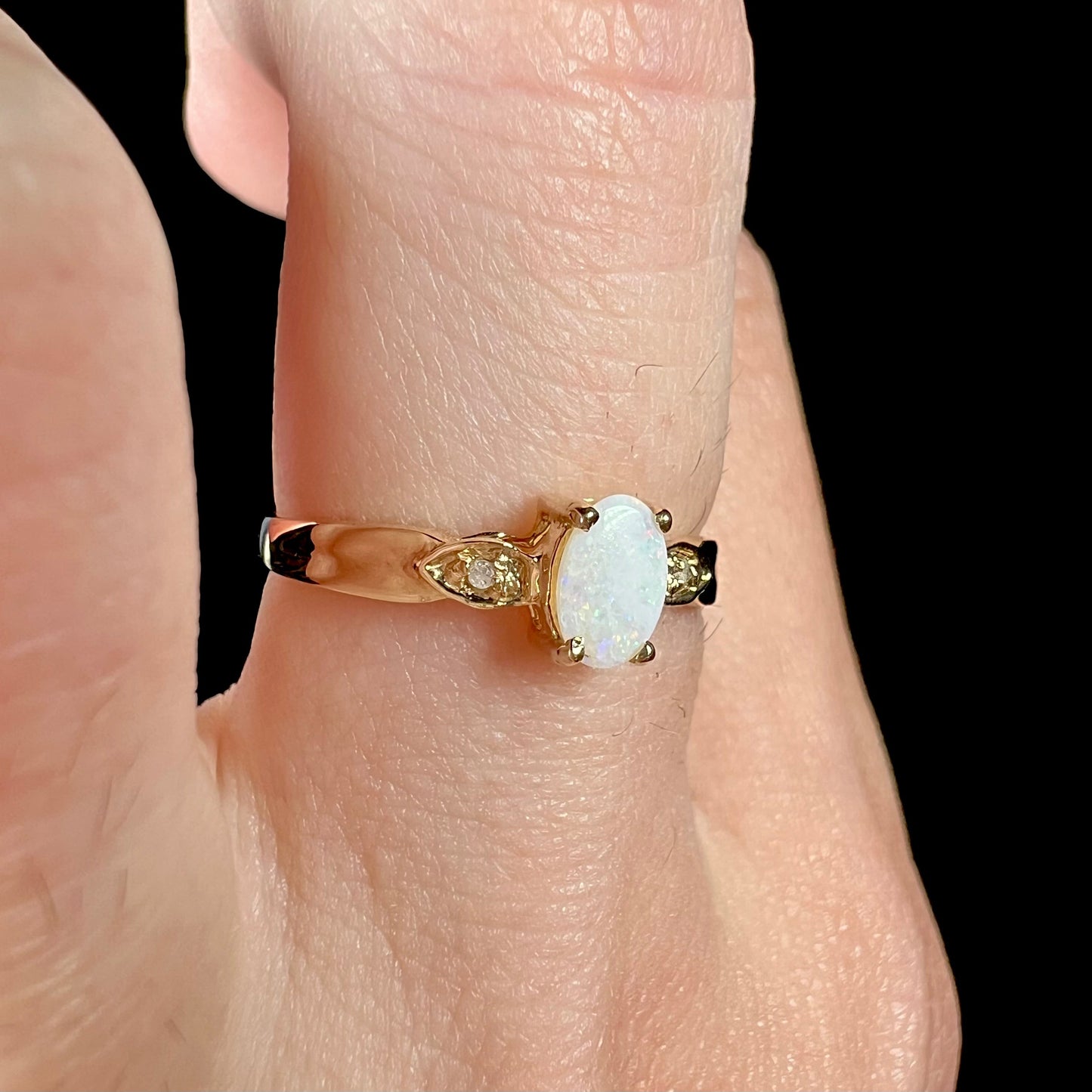 A dainty ladies' yellow gold opal and diamond ring. The opal has subtle play of color.