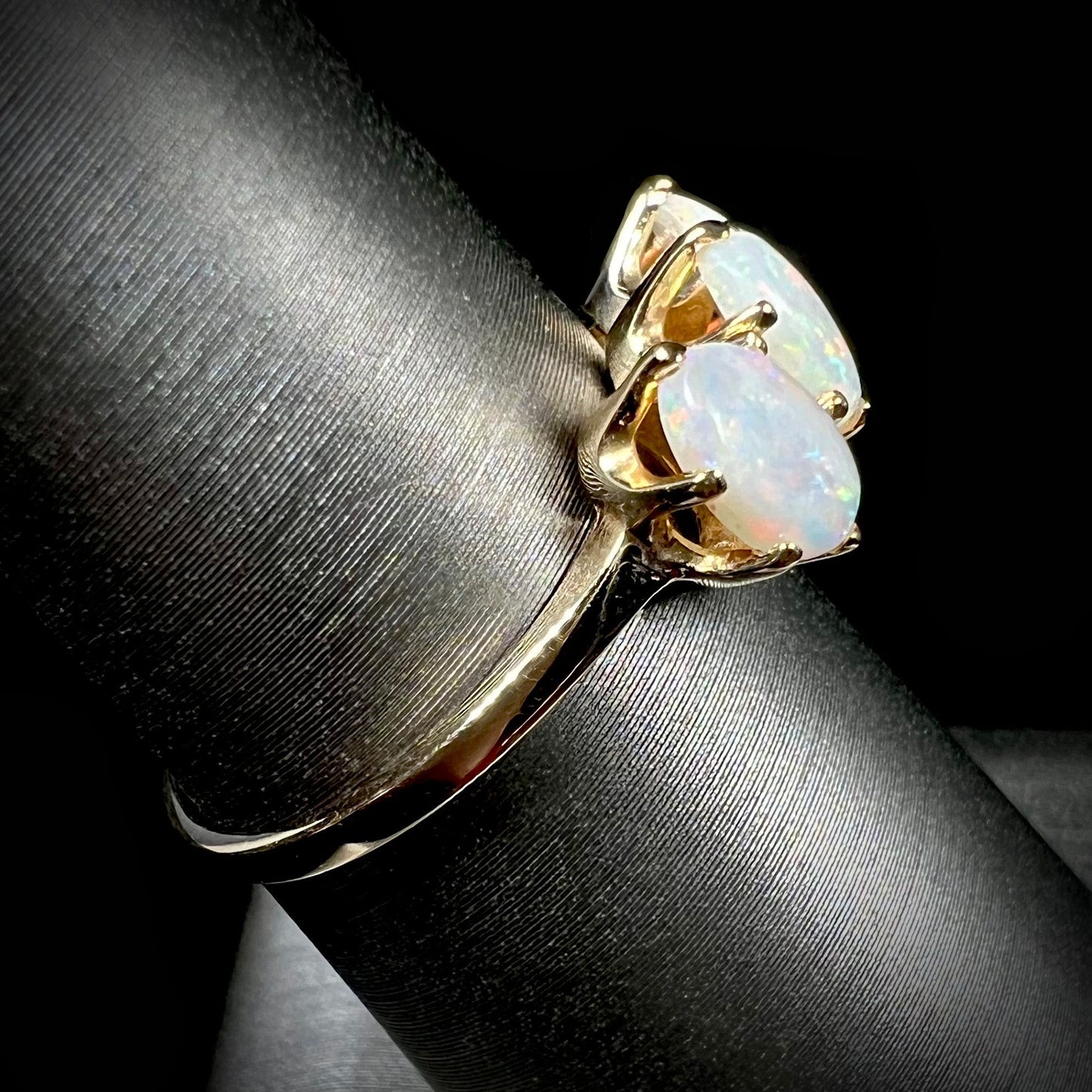 A vintage yellow gold ring mounted with three oval cut white Australian opals.