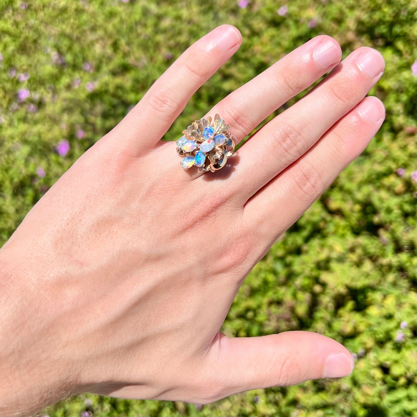 A ladies' vintage, modernist style opal cluster ring in yellow gold. The ring is tall with a high profile.
