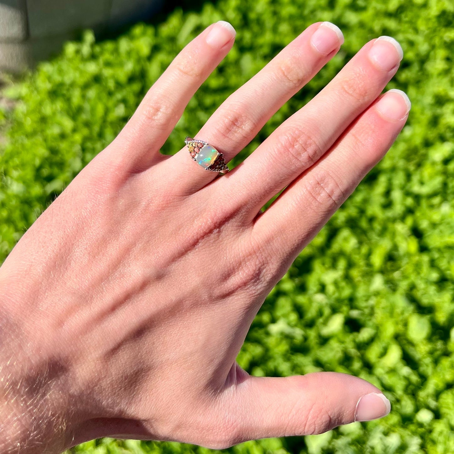 A ladies' silver ring set with a cushion cabochon cut Ethiopian fire opal stone and citrine accents.