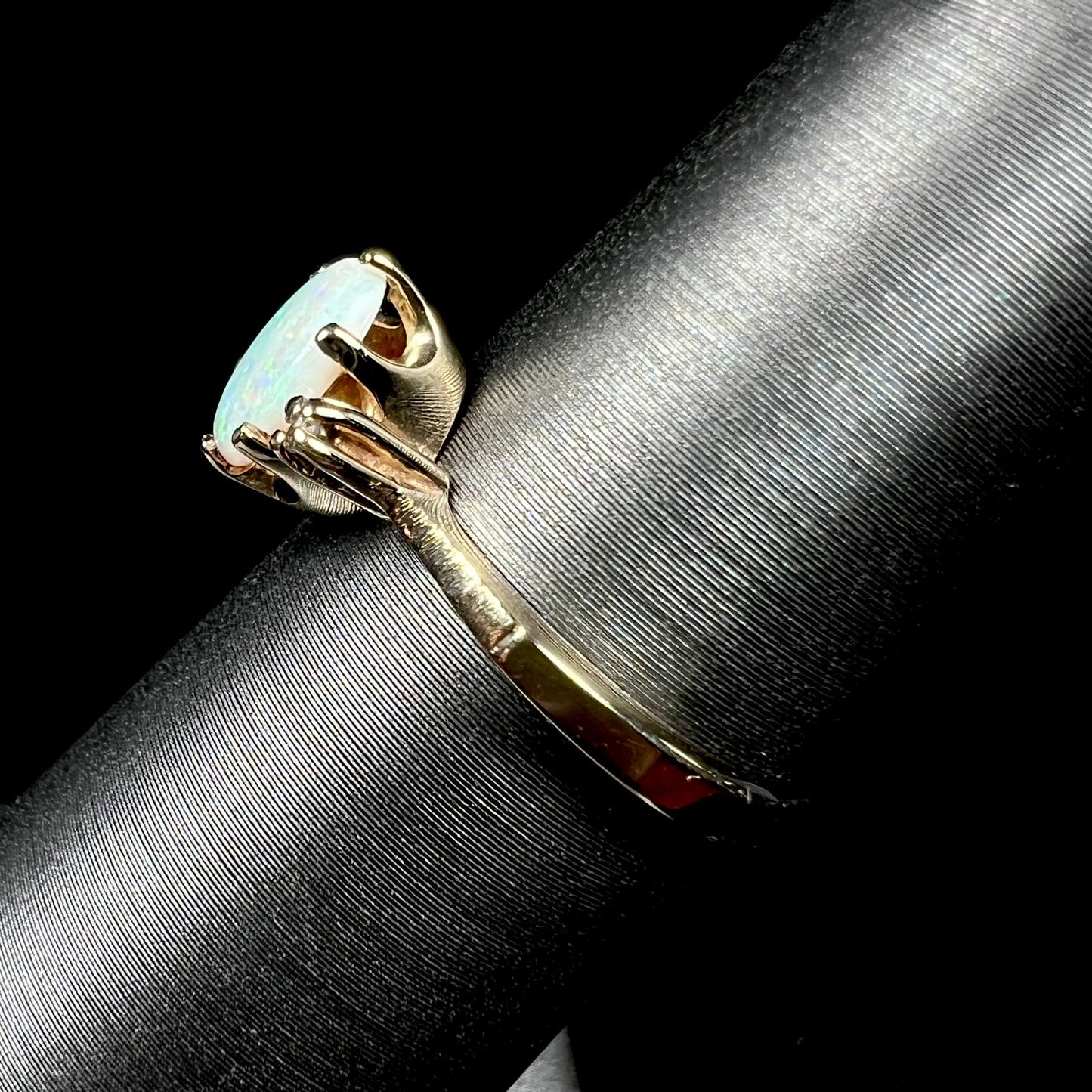 A dainty, 1960's style opal and diamond engagement ring. The ring is prong-set and yellow gold.