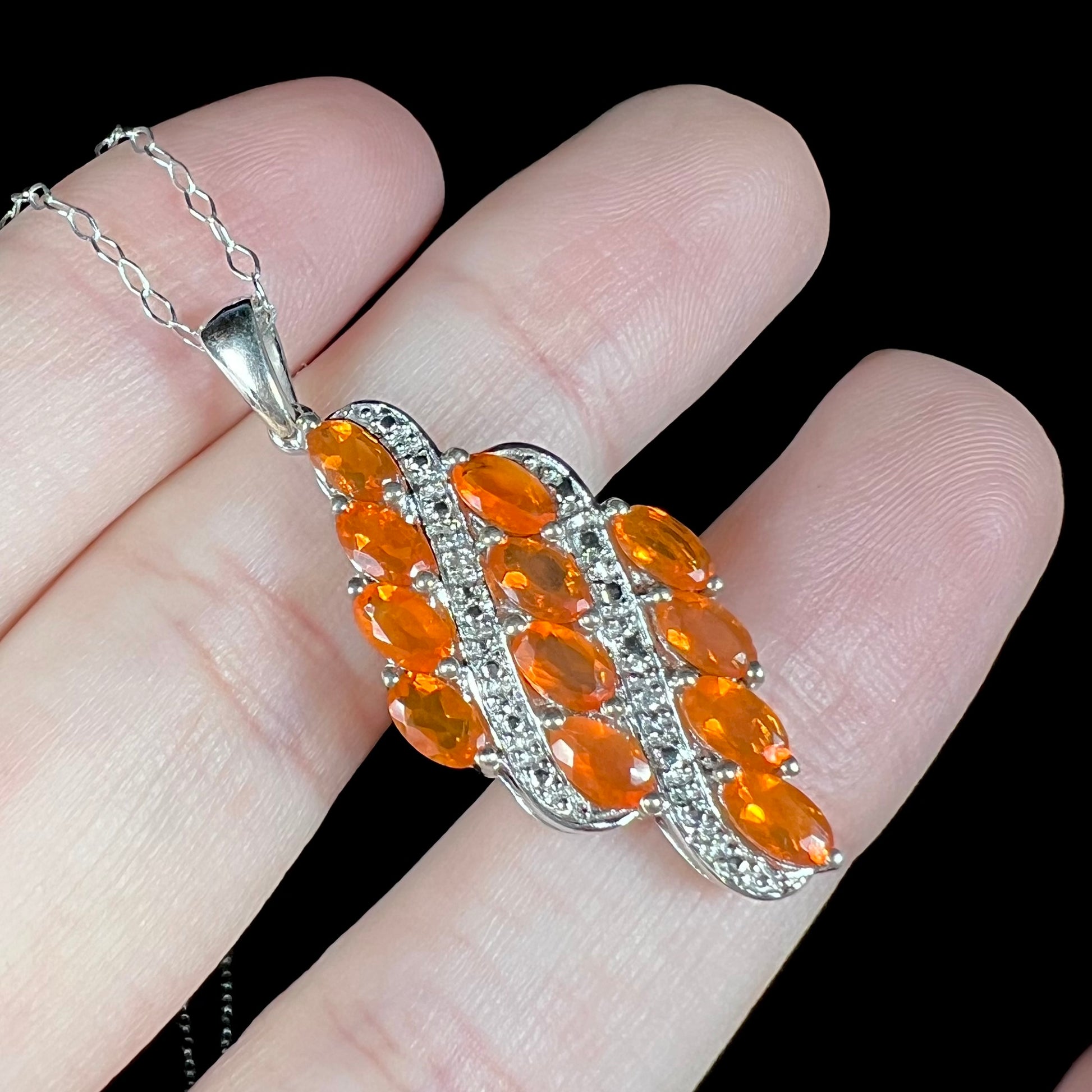A sterling silver Mexican fire opal necklace featuring a cluster of faceted orange fire opals.